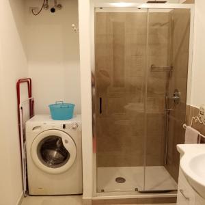 a bathroom with a washing machine and a shower at La Corte di Paola 1 e 2 in Genova
