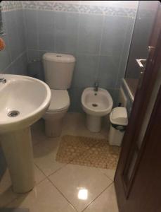 een badkamer met een toilet en een wastafel bij 2 slaapkamers appartement zwembad in Tanger