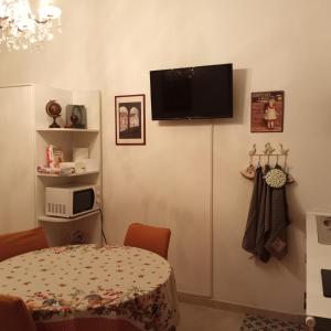 Zimmer mit einem Tisch und einem TV an der Wand in der Unterkunft La Corte di Paola 1 e 2 in Genua