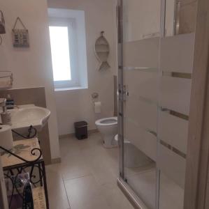 uma casa de banho com um WC e uma cabina de duche em vidro. em La Corte di Paola 1 e 2 em Génova