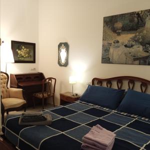 a bedroom with a blue bed and a desk at La Corte di Paola 1 e 2 in Genova