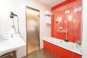 a bathroom with red tiles and a shower and a sink at Allegro Granada in Granada