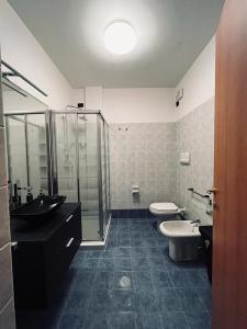 een badkamer met 2 toiletten, een wastafel en een douche bij CASA MIA: appartamento con ogni comfort in Rodengo Saiano