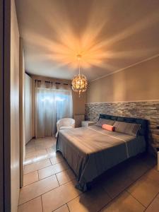 una camera con un grande letto e un lampadario a braccio di CASA MIA: appartamento con ogni comfort a Rodengo Saiano