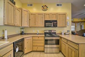 a kitchen with wooden cabinets and a stove top oven at Rustic Las Cruces Escape - 2 Mi to NMSU! in Las Cruces