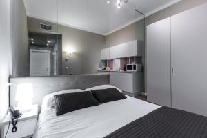 a bedroom with a white bed and a kitchen at Studio Inn De Angeli in Milan