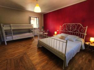 a bedroom with a bed and a red wall at La Tomatica In Commedia in Mongardino