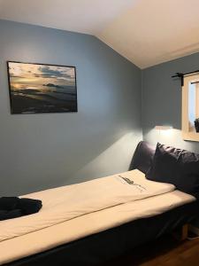 1 dormitorio con 1 cama con una foto en la pared en Northcape Nature Rorbuer - 1 - Dock South, en Gjesvær