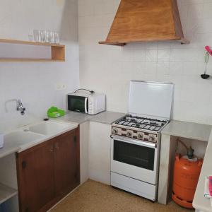 cocina con fogones blancos y microondas en Apartamento centro de peñíscola CASA KIKO, en Peñíscola