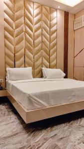um quarto com uma cama grande e uma cabeceira em madeira em SHRADDHA HOTEL em Alīgarh
