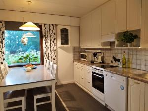 a kitchen with white cabinets and a counter top at Holiday House Mäntyniemi in Hossa