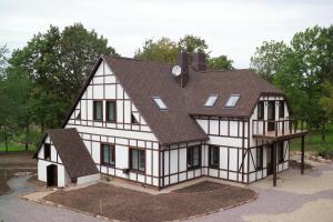 a house with a gambrel roof on top of it at Smuku Muiža in Remte