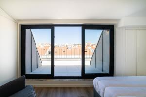 a bedroom with a large window with a view at Lusíadas 53 5ºE - Beautiful River View in Lisbon