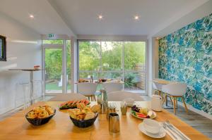a dining room with a table with baskets of food at H&ocirc;tel Le Cottage in Argel&egrave;s-sur-Mer