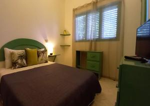 um quarto com uma cama, uma janela e uma televisão em Residence Nord Est em Las Terrenas