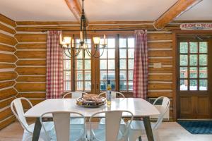 a dining room with a white table and chairs at Family Friendly Private Log Home 6 Person Remote Work Breathtaking Mountain Views Versant Nord in Lac-Superieur +42 photos