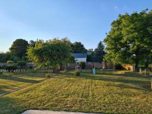 a field with trees and a house in the background at Maison de maître à 2 pas du lac des Settons in Montsauche