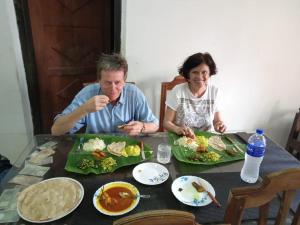 a man and a woman sitting at a table eating food at VALENTINE'S RICE BOWL HOME STAY in Alleppey