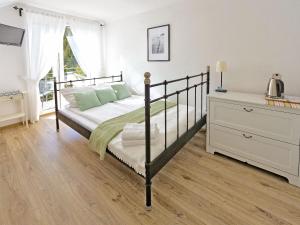 a bedroom with a bed and a dresser at Willa Liliowa in Dębki