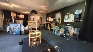 gîte Artbnb في Armbouts-Cappel: غرفة بها لوحات على الحائط وطاولة