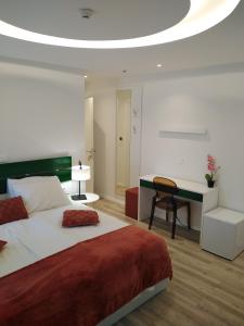 a bedroom with a large bed and a desk at Hotel Villa Elisabeth - Veli Lošinj Health Resort in Veli Lošinj