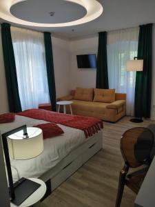 a bedroom with a bed and a couch at Hotel Villa Elisabeth - Veli Lošinj Health Resort in Veli Lošinj