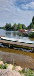 una barca è seduta su un molo in acqua di Ferienhaus - Wohnung- Havelblick a Phöben