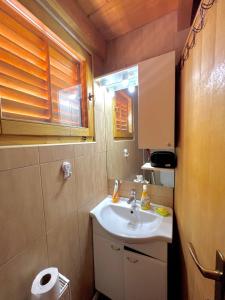 Un baño pequeño con lavabo y ventana. en Vikendica Oaza mira, en Žabljak