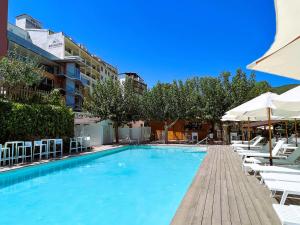 una gran piscina con sillas y sombrillas en Hotel Rosaleda del Mijares en Montanejos