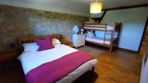1 dormitorio con 1 cama y 1 litera en The Railway Cottage - characterful and comfortable holiday cottage en Piégut-Pluviers