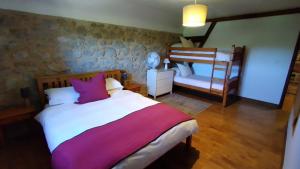 um quarto com uma cama e um beliche em The Railway Cottage - characterful and comfortable holiday cottage em Piégut-Pluviers