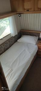 uma cama num pequeno quarto com uma janela em Daniel Studios em Kallithea Halkidikis