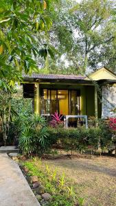 a yellow house with a lot of plants in front of it at Baan Bua Cottage SHA EXTRA PLUS B5510 in Ko Kood