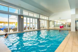 uma grande piscina com uma pessoa na água em Hotel Sol e Mar Albufeira - Adults Only em Albufeira