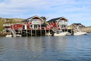 un grupo de casas en un muelle en el agua en Northcape Nature Rorbuer - 3 - Dock North, en Gjesvær