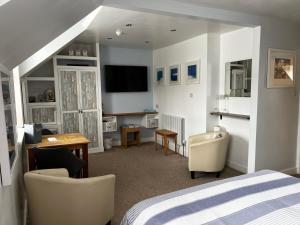 sypialnia z łóżkiem, biurkiem i telewizorem w obiekcie Wenden Guest House w Newquay