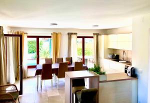 Una cocina y un comedor con mesa y sillas. en Villa "San Servolo House" with sea view and private heated pool!, en Buje