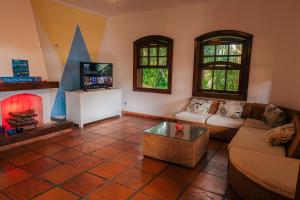 sala de estar con sofá y TV en Beer Hostel Suites Privativas e Compartilhadas, en Ilhabela