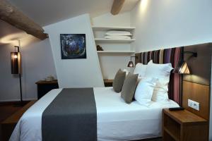 Schlafzimmer mit einem Bett mit weißer Bettwäsche und Kissen in der Unterkunft L'Hostalet in Argelès-sur-Mer