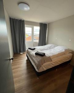 um quarto com uma cama e uma grande janela em Stykkishólmur house em Stykkishólmur