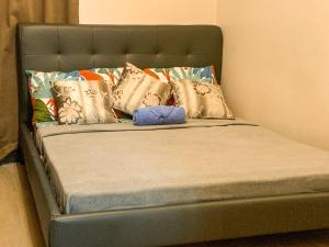 een bed met kussens en een blauw voorwerp erop bij Fairway Terraces Resort Staycation in Manilla