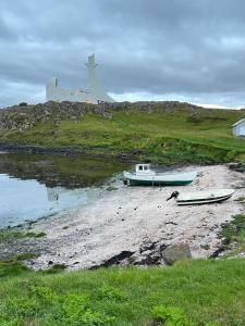 two boats sitting on the shore of a body of water at Stykkishólmur house in Stykkishólmur