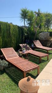 two wooden benches sitting on the grass in a yard at Villa ANOLPA in Vence