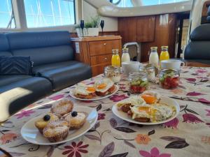a table with plates of breakfast food on it at Sailing 360 Night On Board Experience in Vila Nova de Gaia