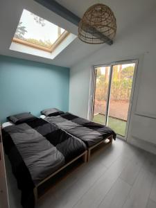 比斯卡羅斯海灘的住宿－maison landaise à proximité de la plage et centre，一间卧室设有一张床和一个大窗户