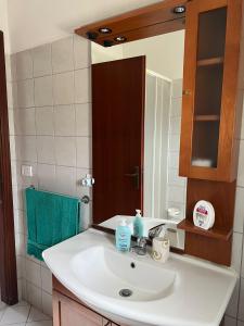 een badkamer met een witte wastafel en een spiegel bij Relax natura in Agrigento