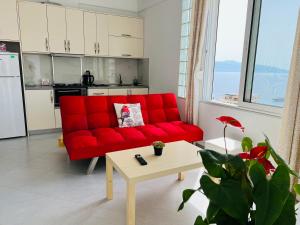a red couch in a living room with a table at TERRACE VIEW APARTMENTS in Sarandë