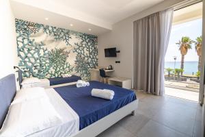 a bedroom with a bed and a large window with the ocean at MARINO WELLNESS in Alì Terme +75 photos
