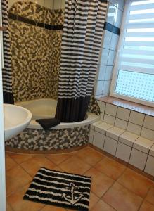 W łazience znajduje się wanna, umywalka i prysznic. w obiekcie Koralle w mieście Boltenhagen