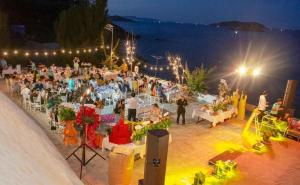 una folla di persone sedute ai tavoli a una festa di notte di RUBEACH HOTEL & REROST a Song Cau